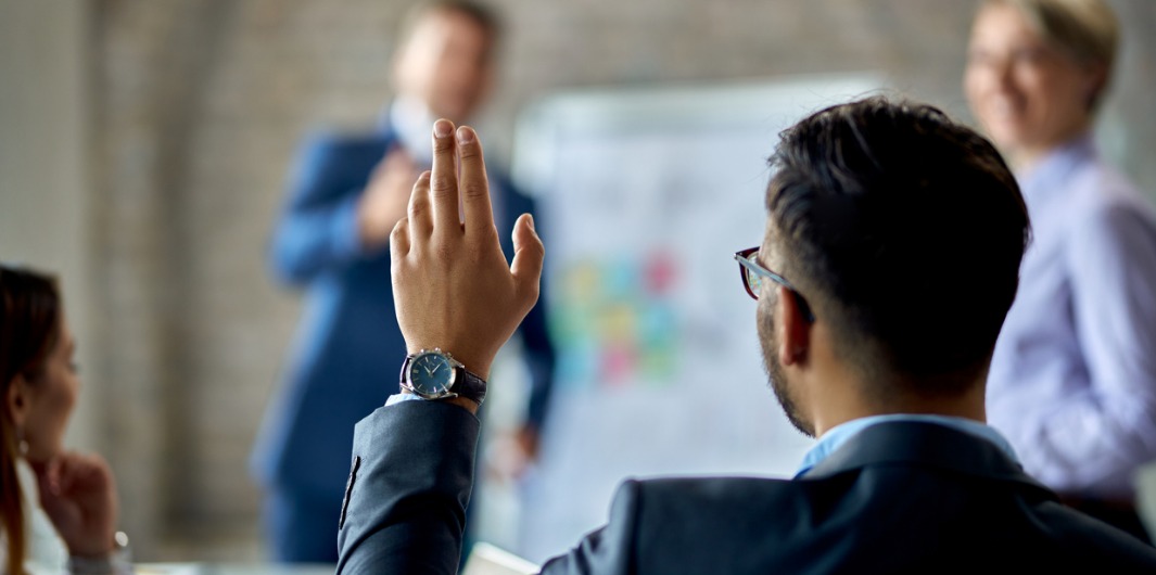 A man raising hand to ask questions